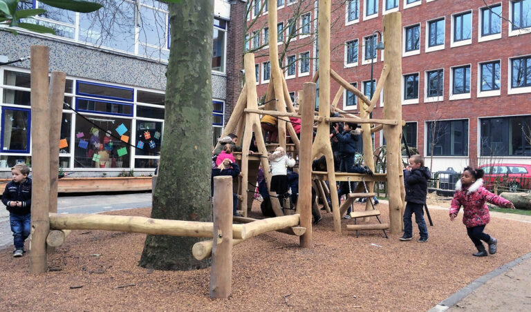 Speeltoestel rond boom op een schoolplein