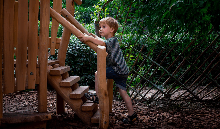 Houten speeltoestel met spelende kleuter