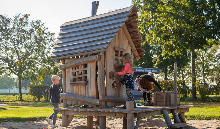 Kinderen spelen bij robiniahouten speelhuisje strandwinkel