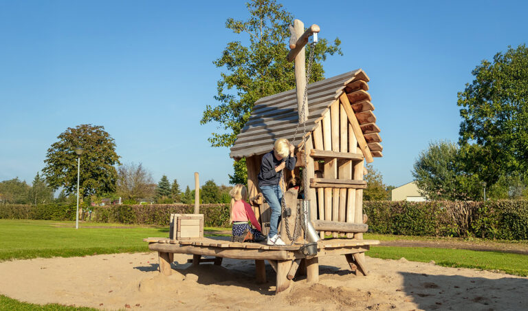 Zandspeeltoestel van robiniahout met zandbuis op speelplek