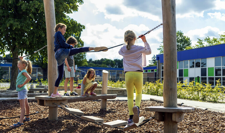 Detailfoto van balancerend kind over plankjesbrug op speeltoestel