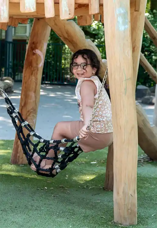 Meisje speelt in net in speeltoestel