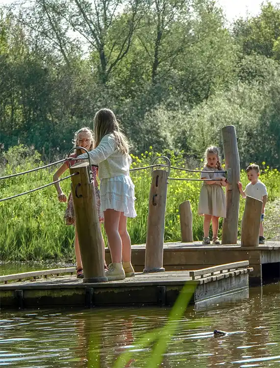 Kinder spelen op trekvlot op recreatiepark